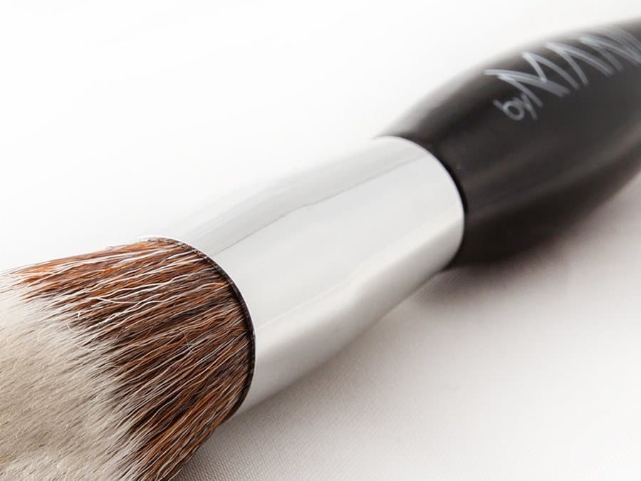 De chromen ferrule van een byMANI-kwast waar hij overgaat in de zwarte greep